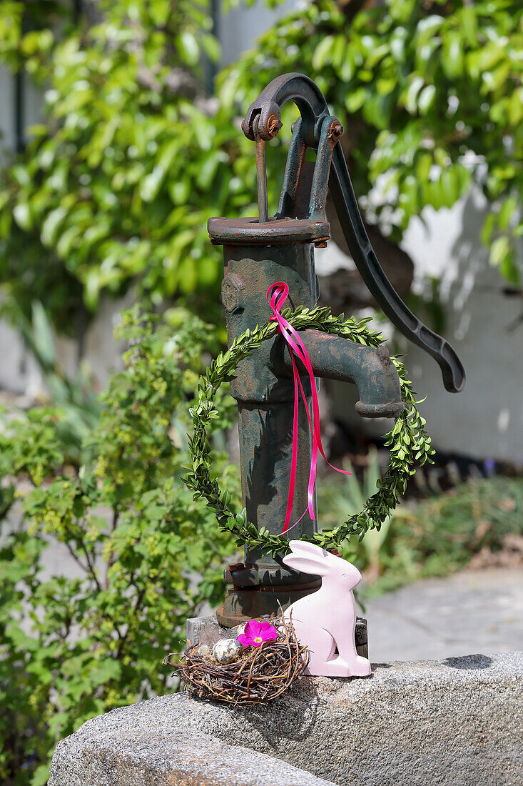 Vintage water pump with wreath, small Easter nest and Easter bunny