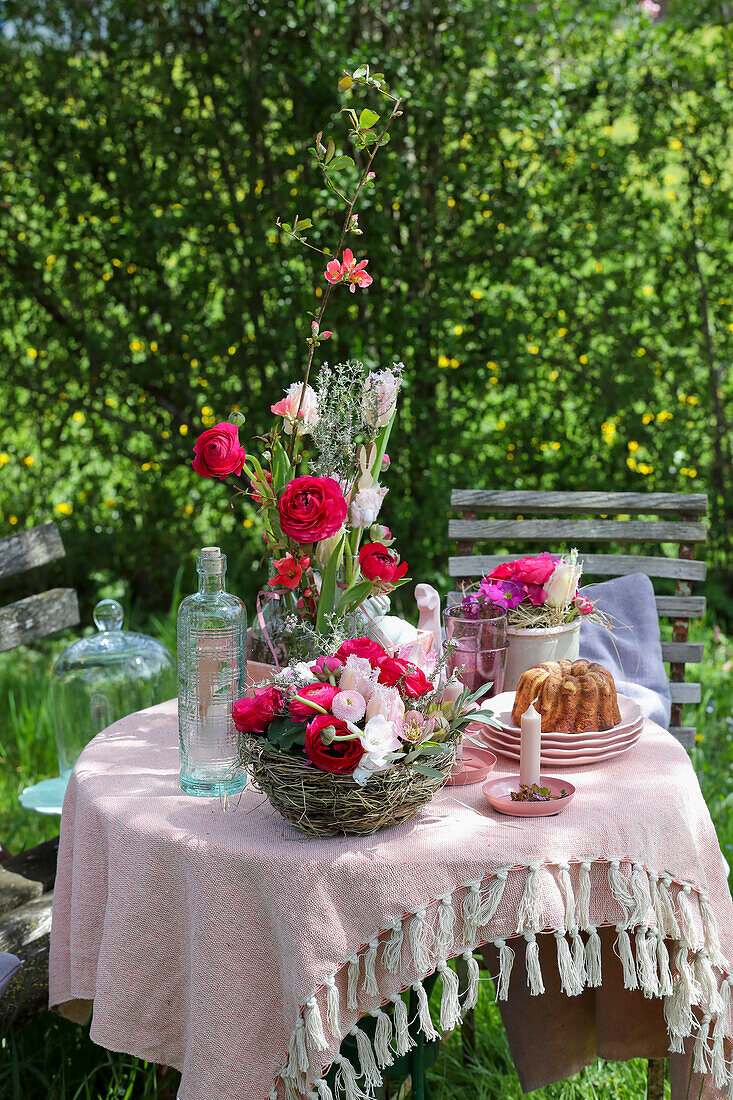 Garden table with spring flowers and cake