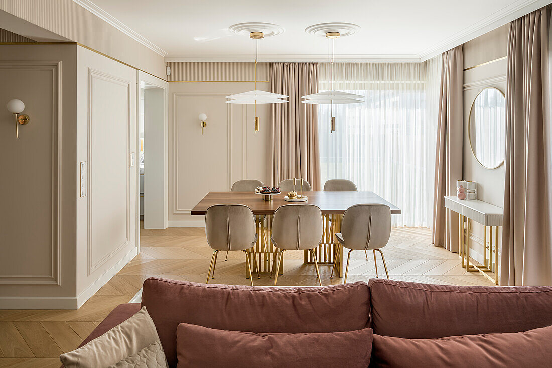 Blick über Sofa auf Essbereich in elegantem Wohnraum in Pastelltönen