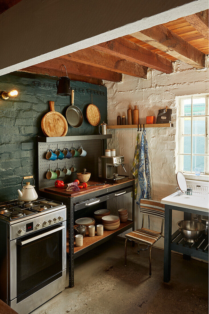 Küche im Landhausstil mit freiliegenden Balken und Steinwand