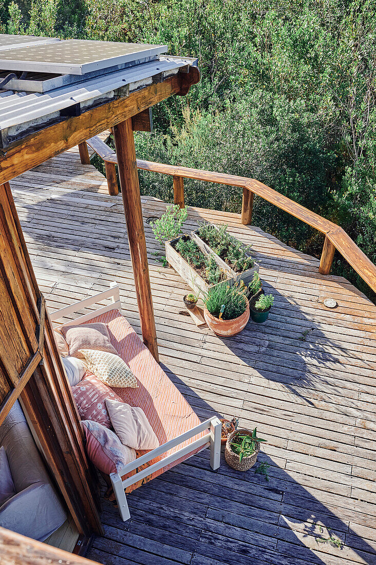 View from above of wooden terrace with day bed