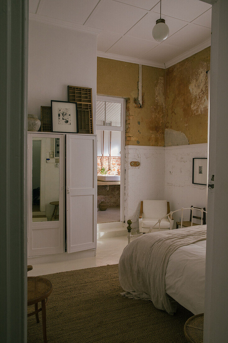 Schlafzimmer mit Vintage-Flair, rohe Wandtextur und minimalistische Einrichtung