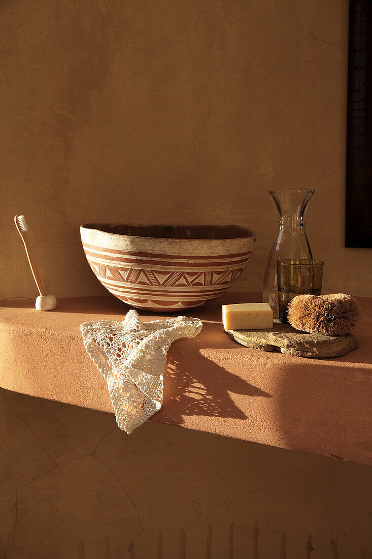 Brick shelf with clay bowl and washbasin items