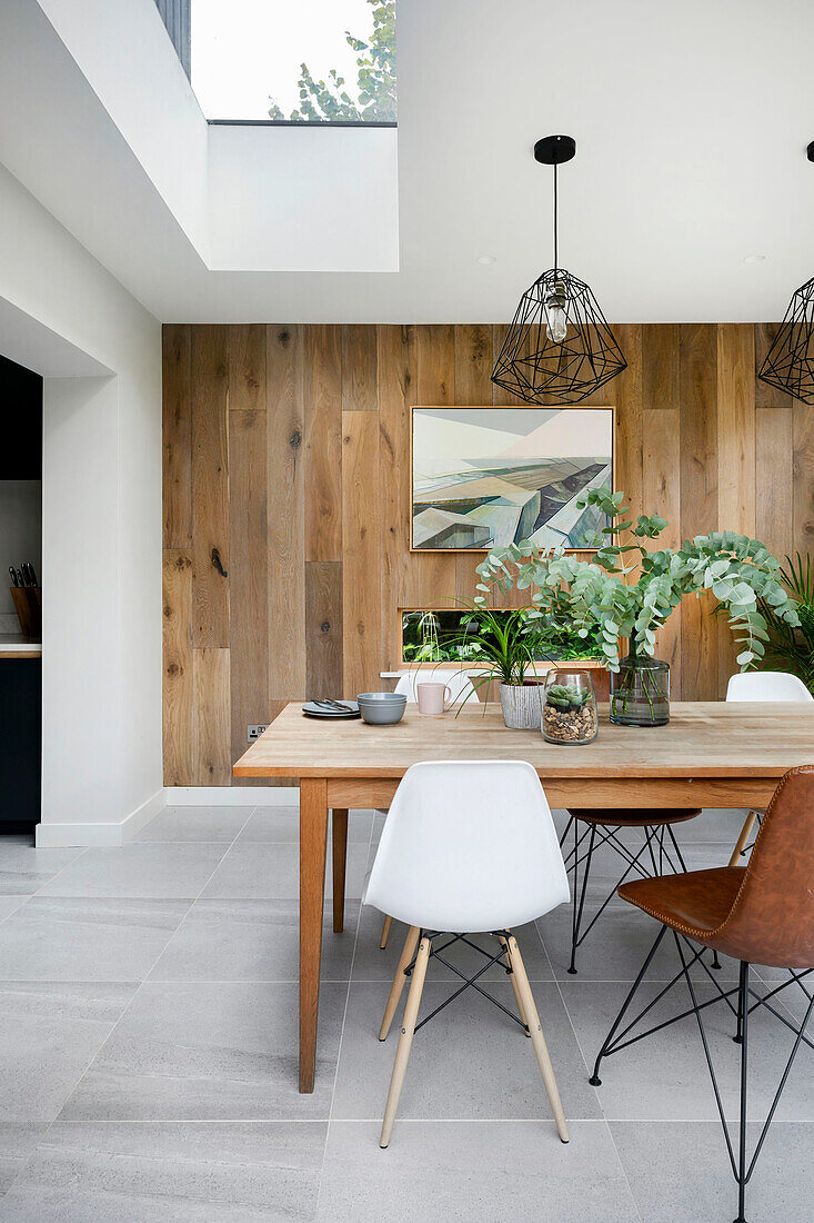 Bright dining area with skylight in front of oak plank wall panelling