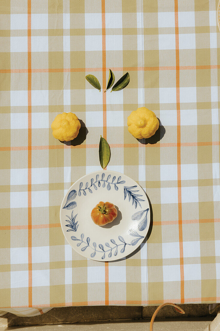 Plate with botanical pattern on checkered tablecloth