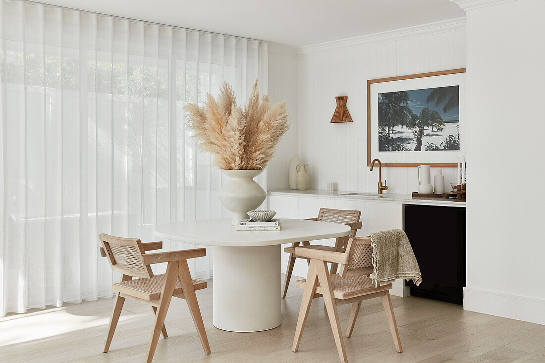 Modernes Esszimmer im Küstenstil, Esstisch mit Steinsäule und Replica Designerstühlen