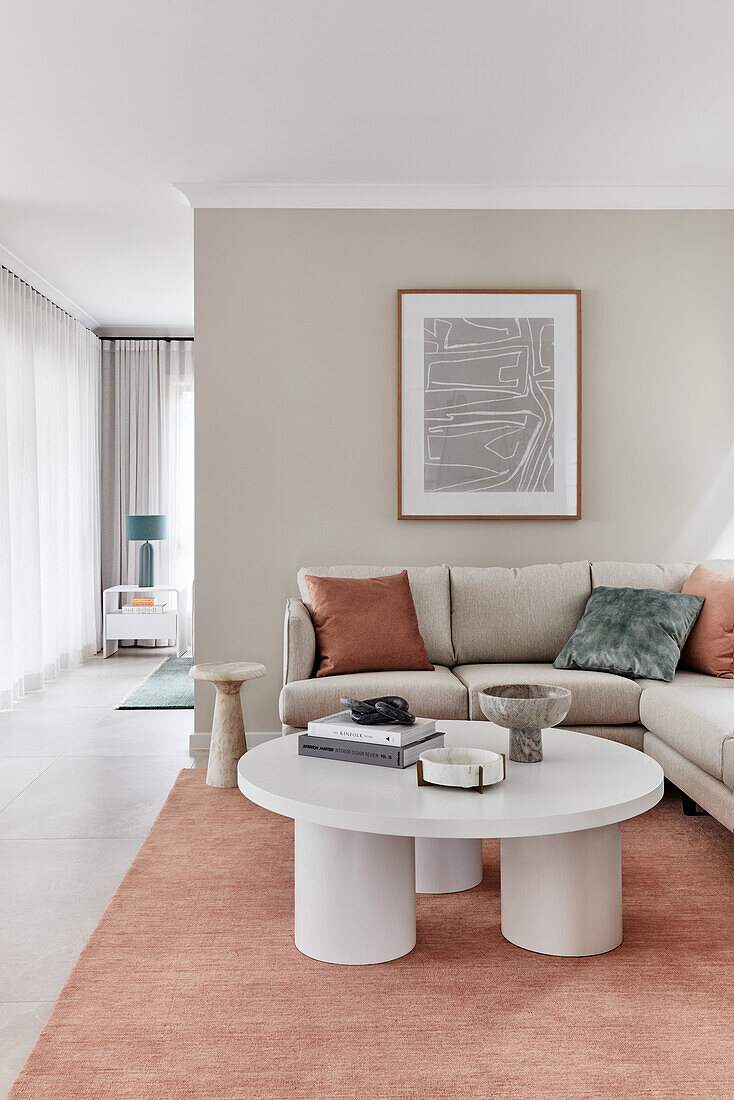 Modern Scandi style living room with columned coffee table, cream linen sofa, and terracotta rug