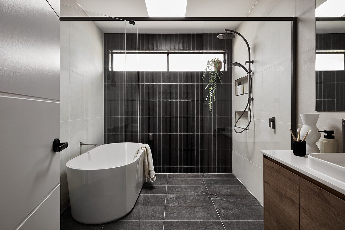 Large, modern bathroom with glass walls and freestanding bathtub