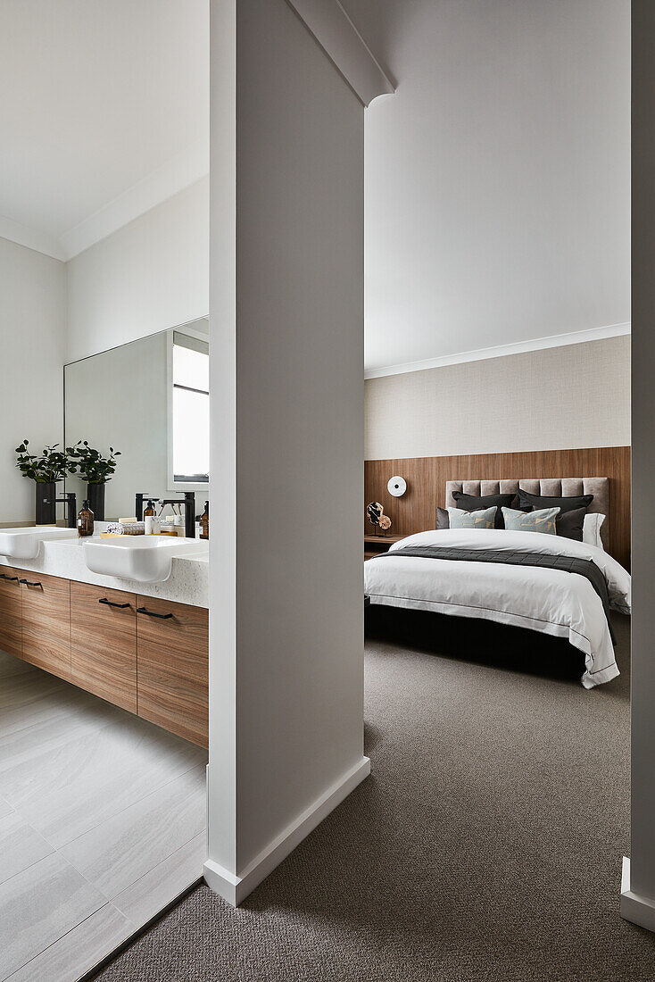 Modernes, in neutralen Tönen gehaltenes Schlafzimmer mit eigenem Bad