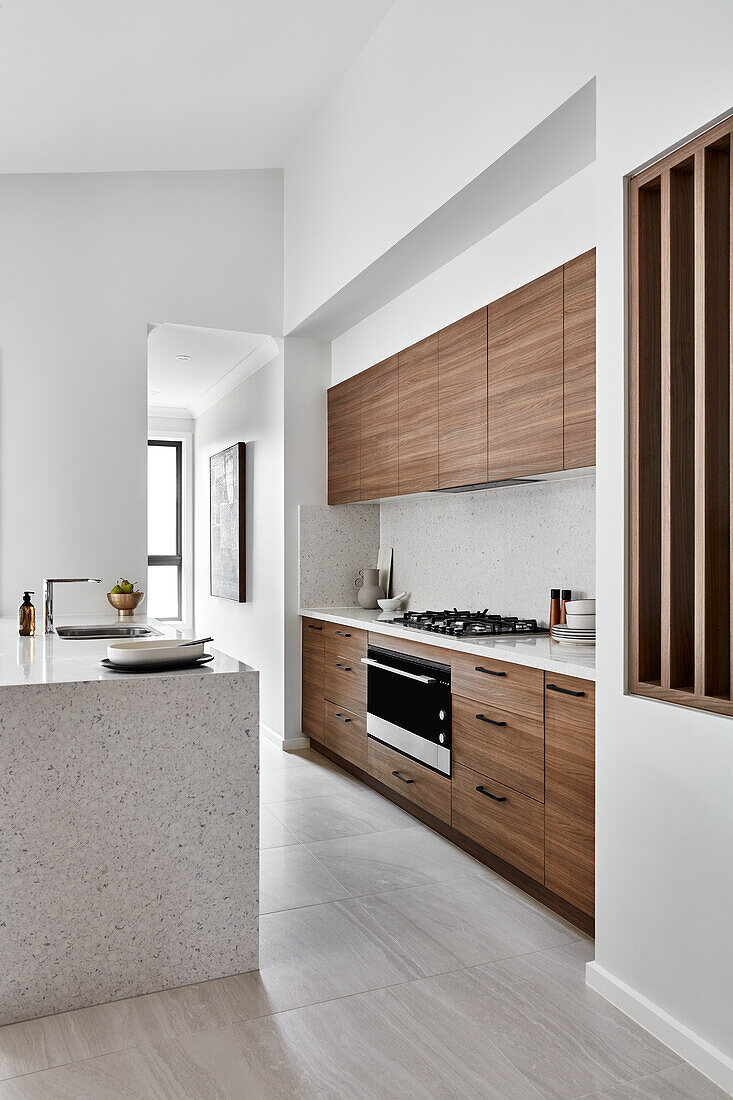 Moderne, in neutralen Tönen gehaltene Küche mit Holzfronten und mit Kücheninsel