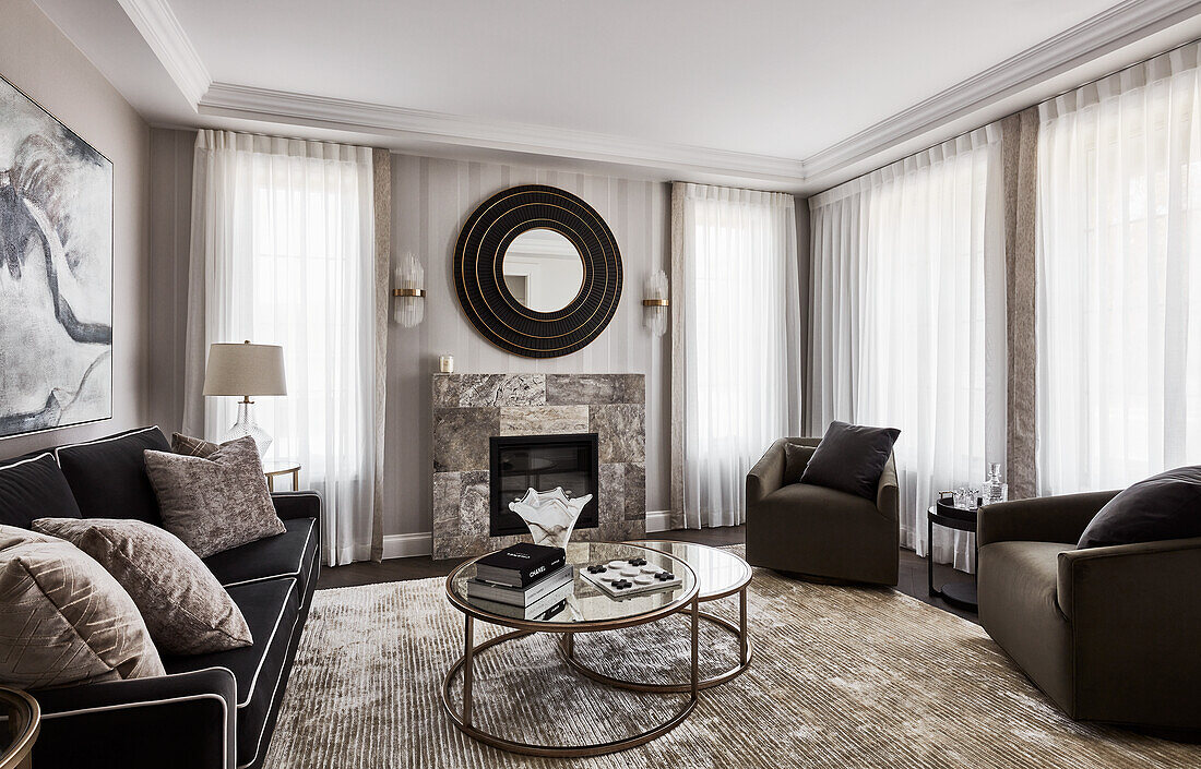 Traditional living room with velvet sofas, marble and metal coffee tables, and stone fireplace