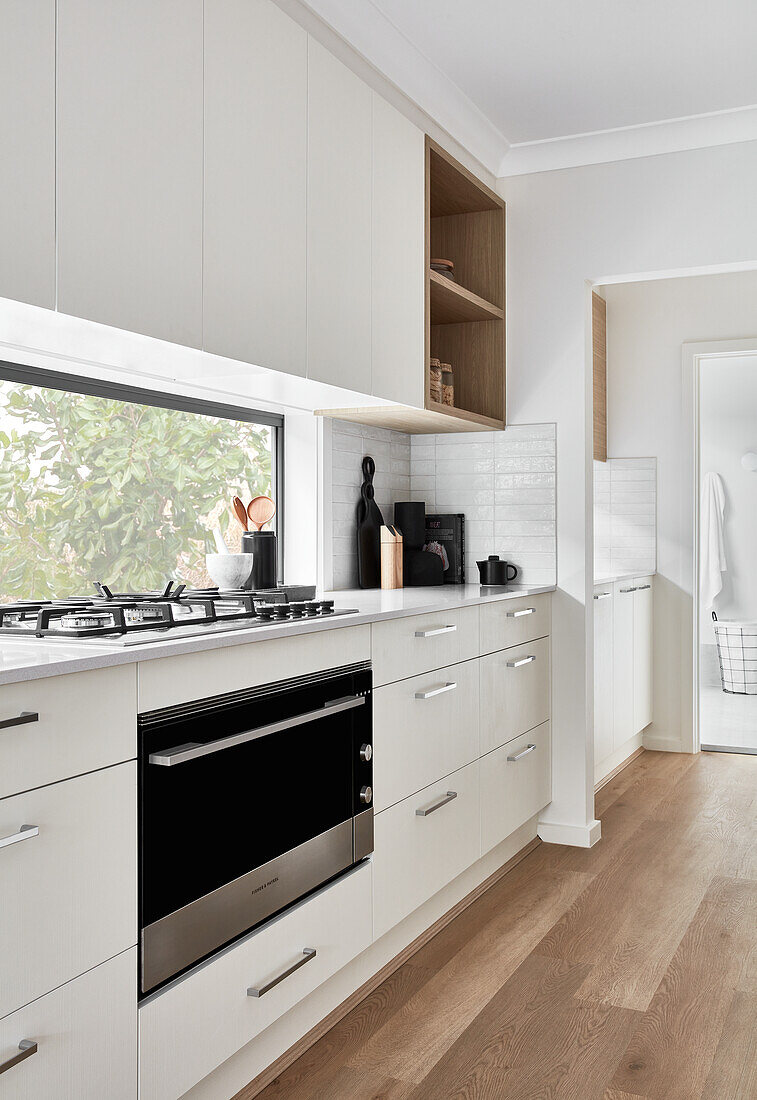 Moderne weiße Küche und Waschraum im Hintergrund