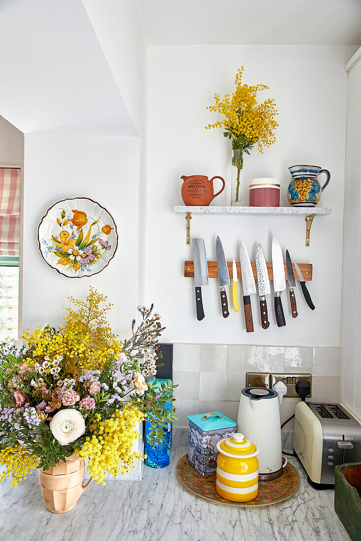 Küche mit Blumenstrauß und Messerhalter an der Wand