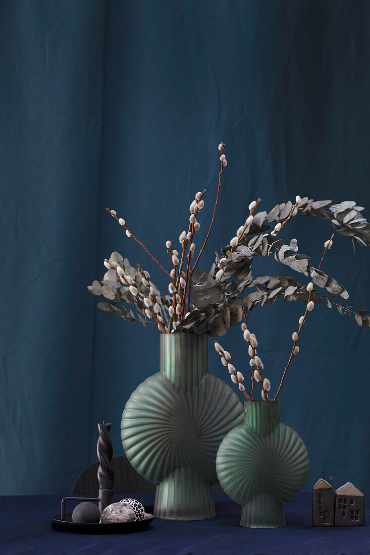 Dark green shell vases with palm catkins and eucalyptus branches