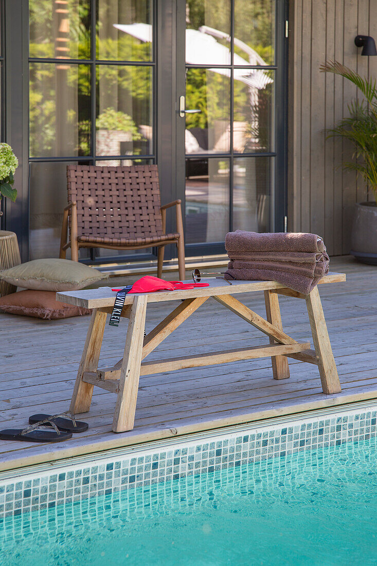 Wooden furniture on terrace next to swimming pool
