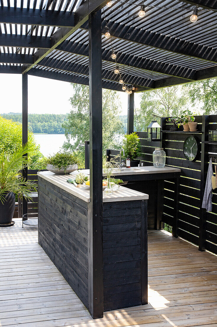 Outdoor kitchen with wooden paneling and string lighting