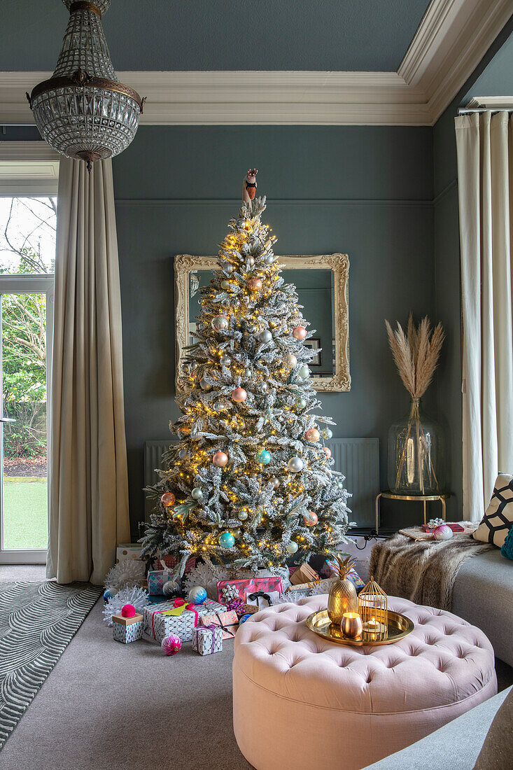 Christmas tree decorated with presents in elegant living room
