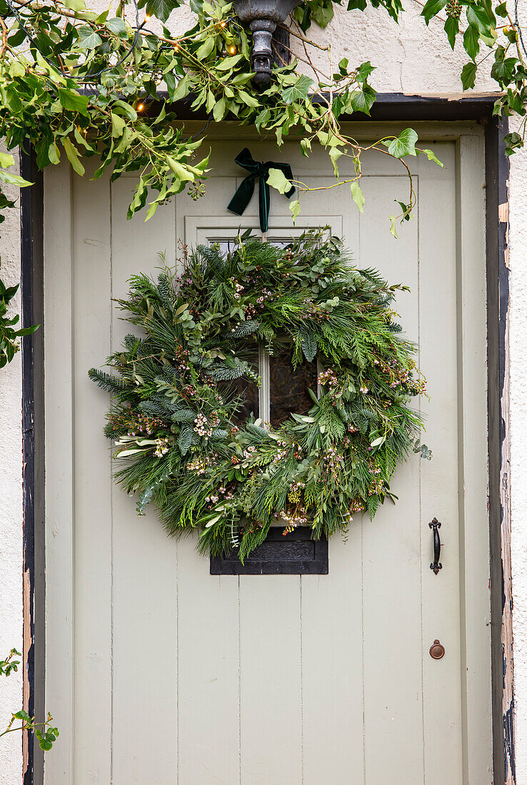 Weihnachtlicher Türkranz mit Tannenzweigen an einer Haustür