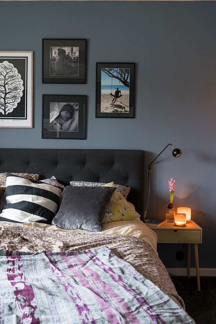 Modern bedroom with blue-grey wall and picture gallery