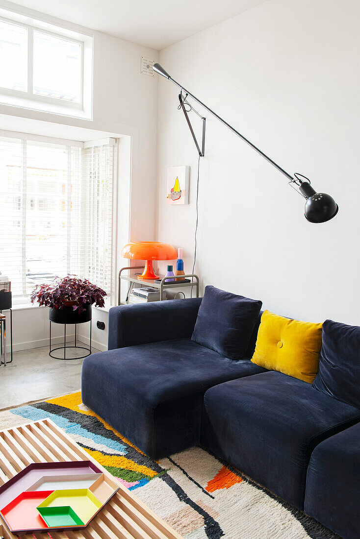 Living room with blue sofa and wall lamp