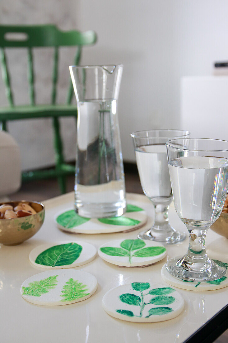 Water glasses and carafe on table with homemade coasters