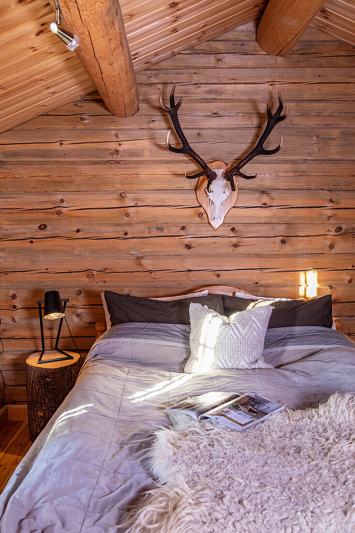 Chalet bedroom with antler decorations and fur throw on the bed