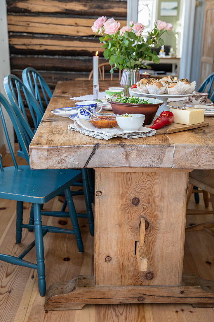 Rustic dining table with blue chairs and country-style decorations