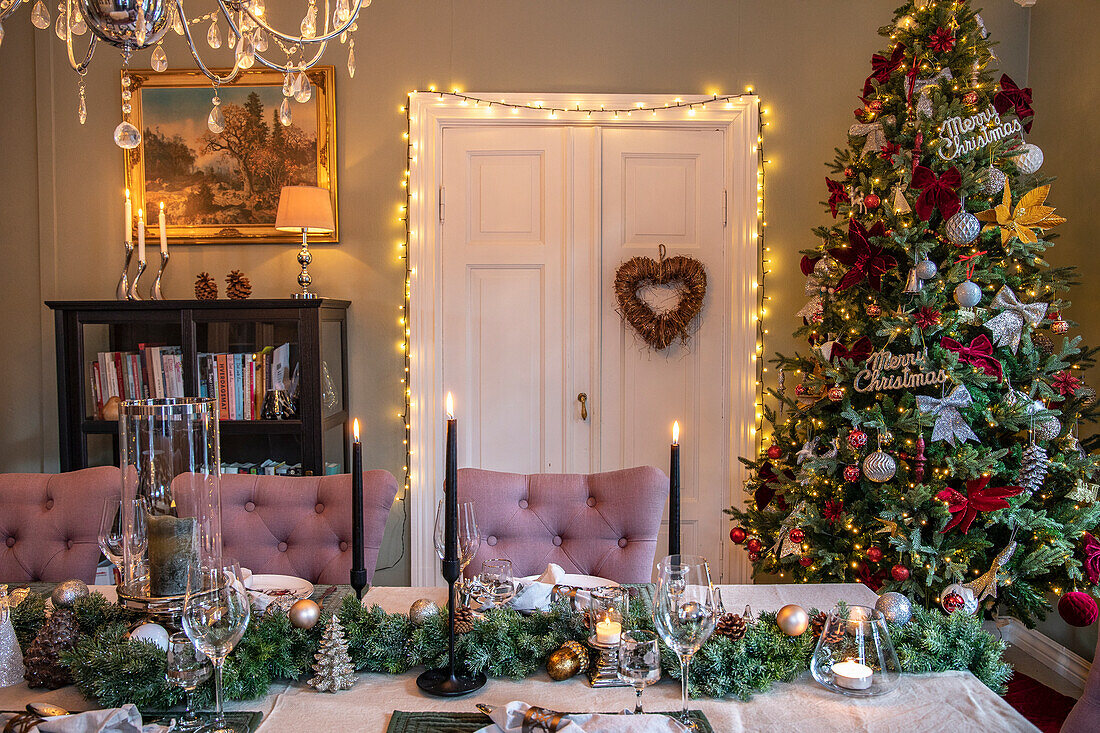 Festively decorated dining area with Christmas tree and candlelight