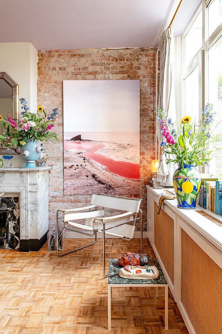 Living room with parquet floor, fireplace and colorful bouquets of flowers