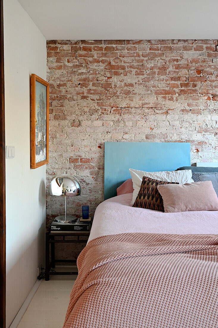 Bedroom with bed in front of exposed brick wall