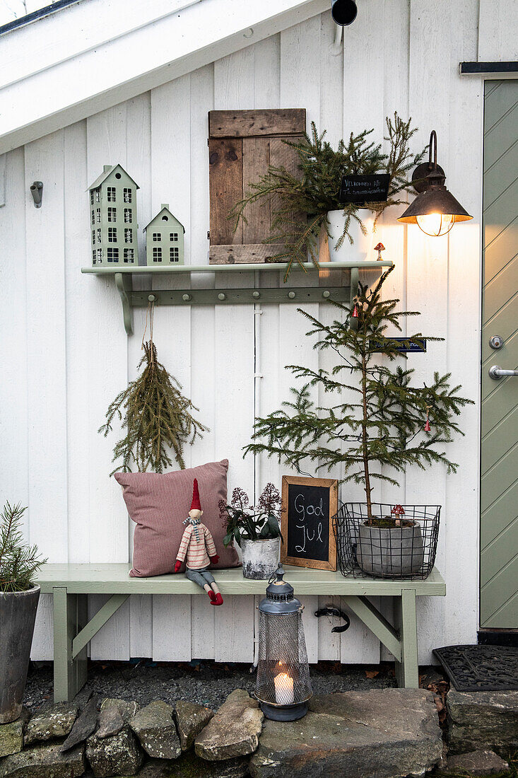 Weihnachtlich dekorierte Veranda mit mit Sitzbank und Beleuchtung