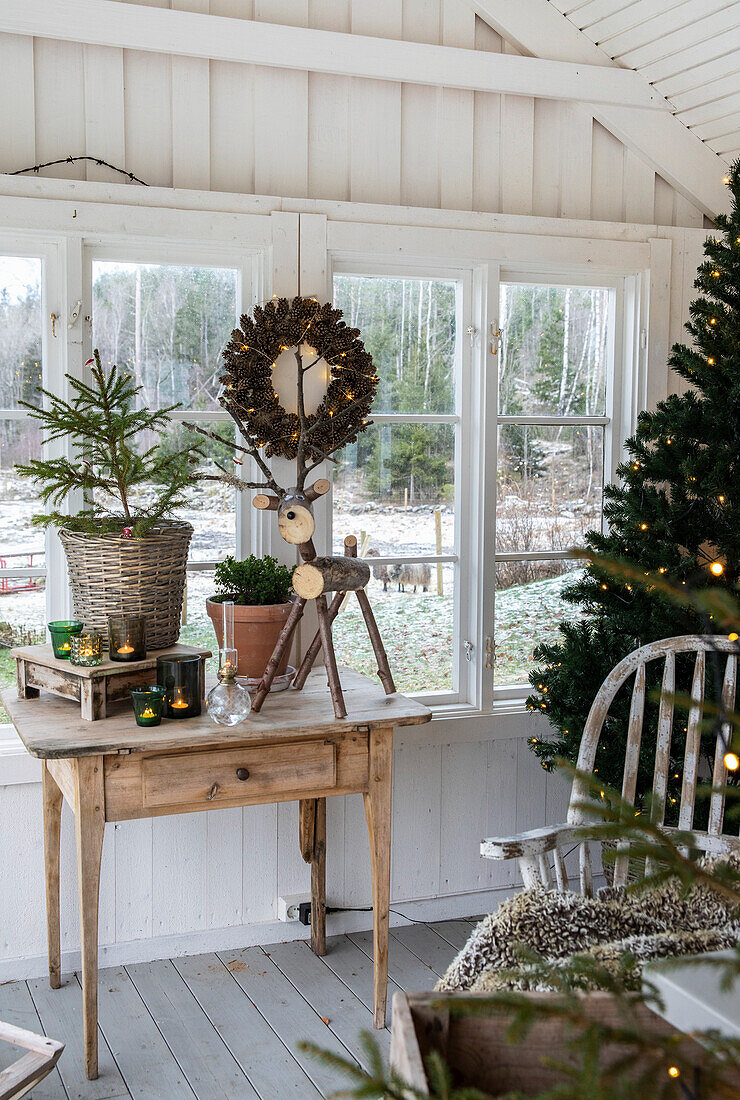 Winter decoration on wooden table with Christmas tree, reindeer figure and candles
