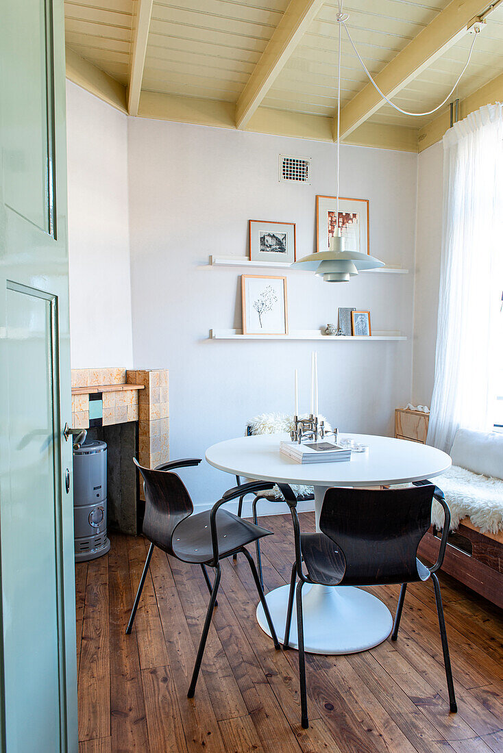 Dining area with round table, black chairs and wood-burning stove in the corner