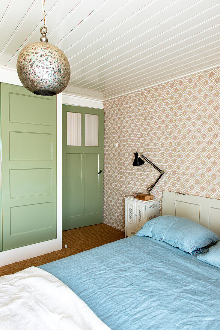 Bedroom with green door and patterned wallpaper