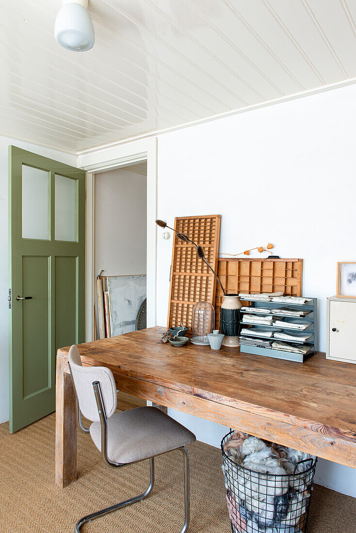 Wooden desk with chair in the study, green door and decorative elements