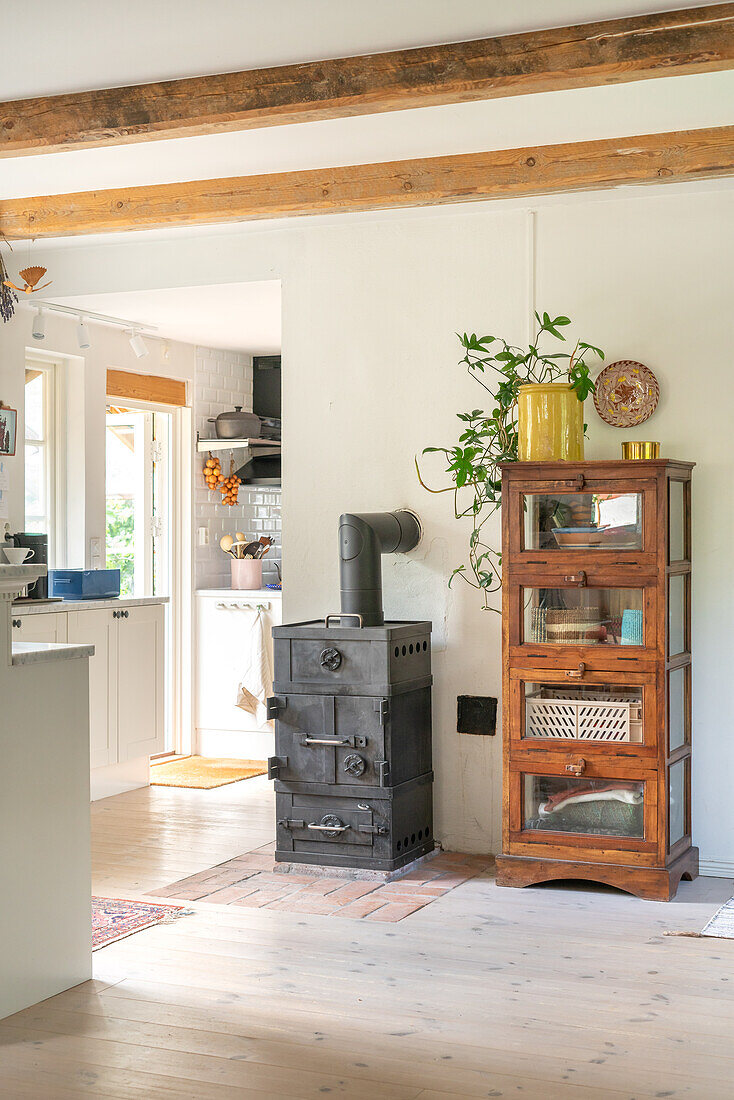 Blick auf Landhausküche, Ofen und Vitrinenschrank aus Holz
