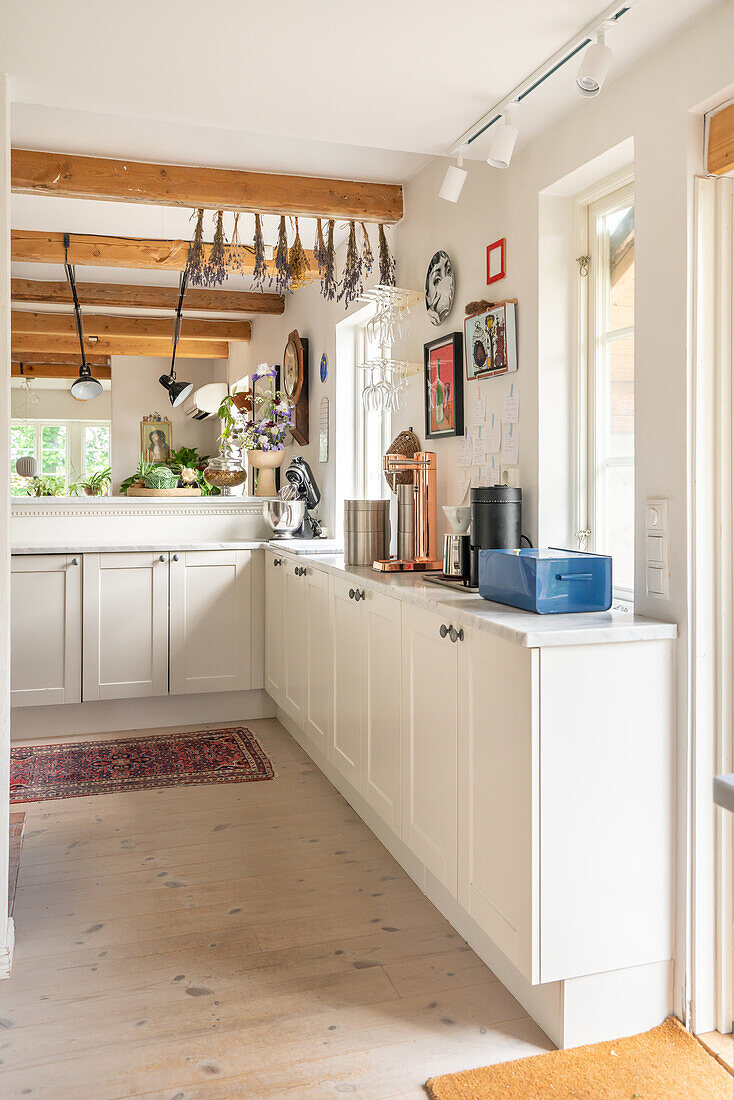 Country kitchen with wooden beams and white furnishings