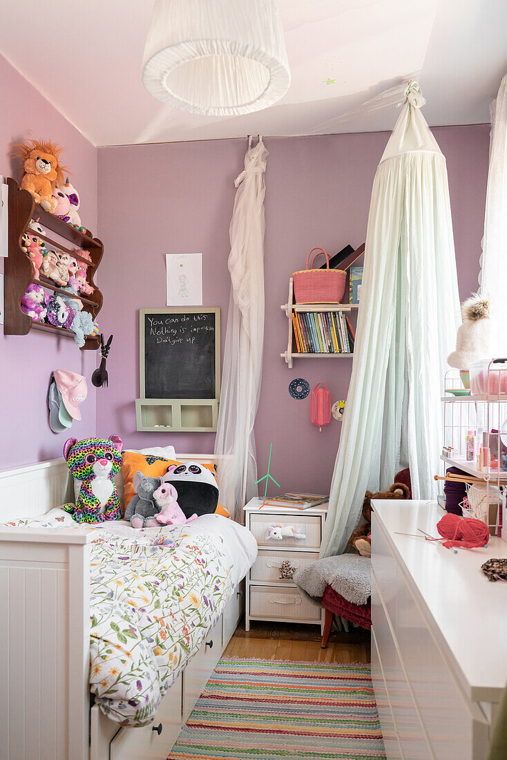 Children's room with purple walls, bed and cuddly toys