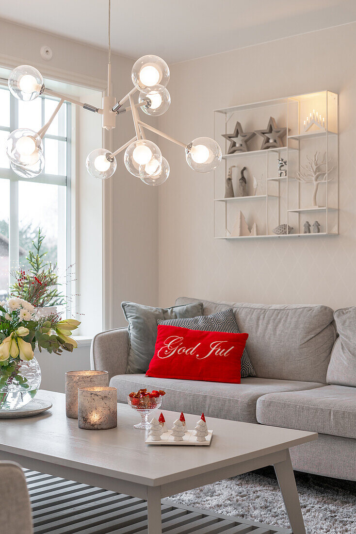 Living room with sofa, Christmas decorations and the words God Jul on pillow