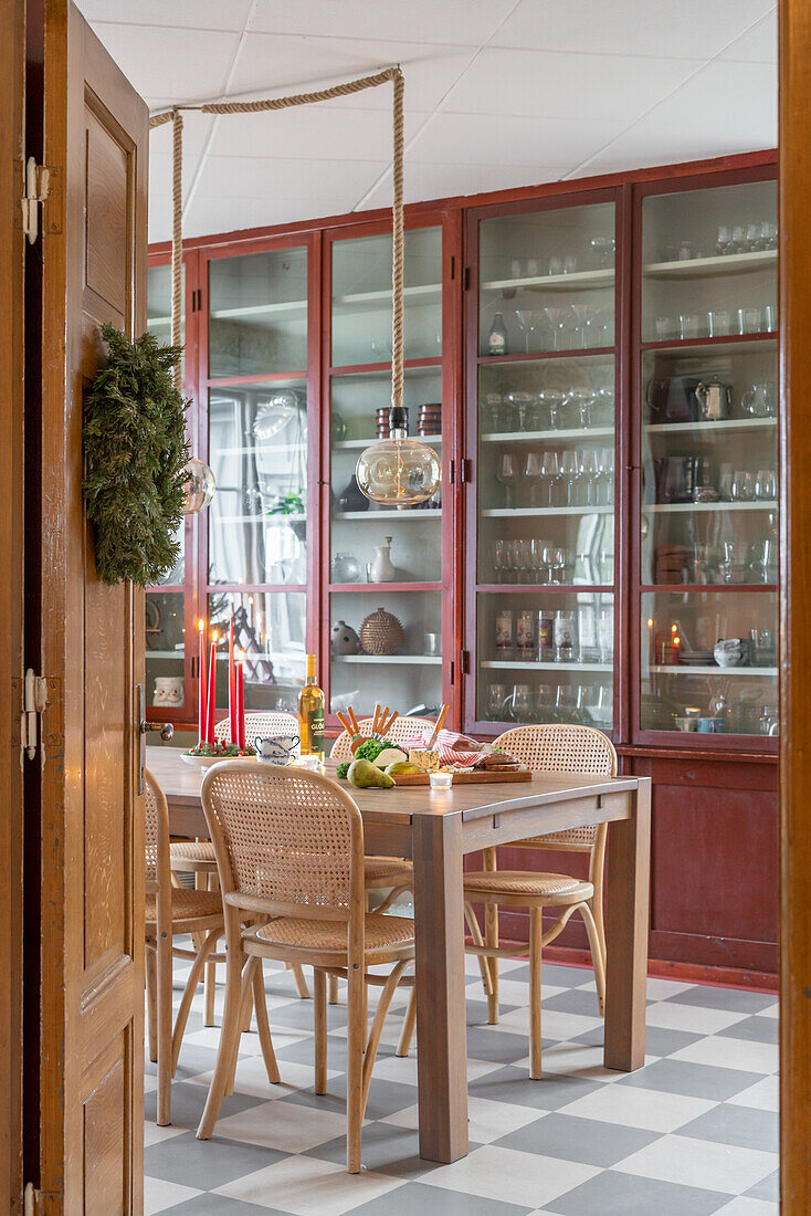 Dining area with rattan chairs and display cabinet in red-brown