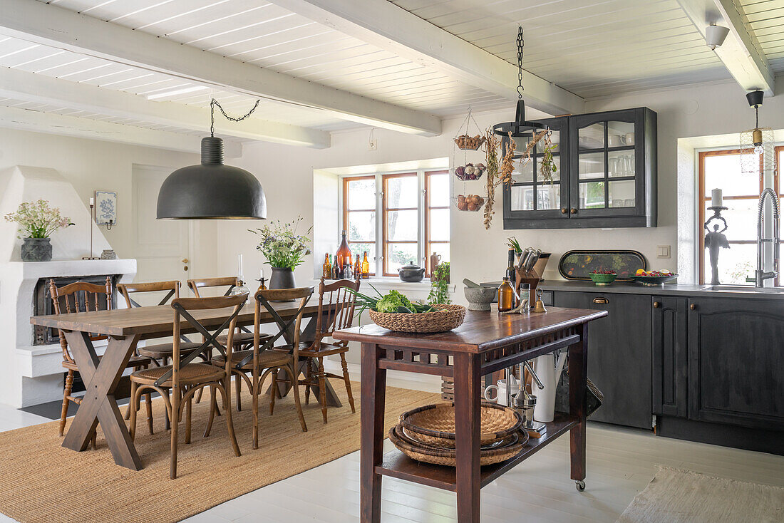 Spacious country kitchen with wooden dining table and dark grey cupboards