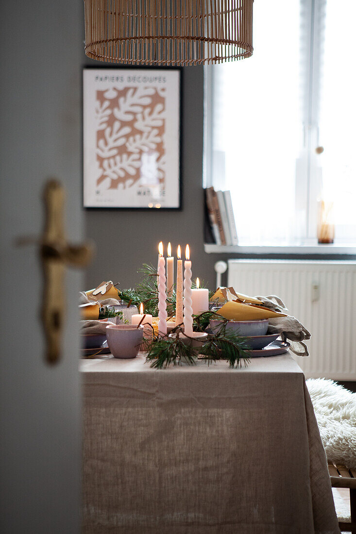 Gedeckter Tisch mit Kerzen und Tannenzweigen, Leinen-Tischdecke