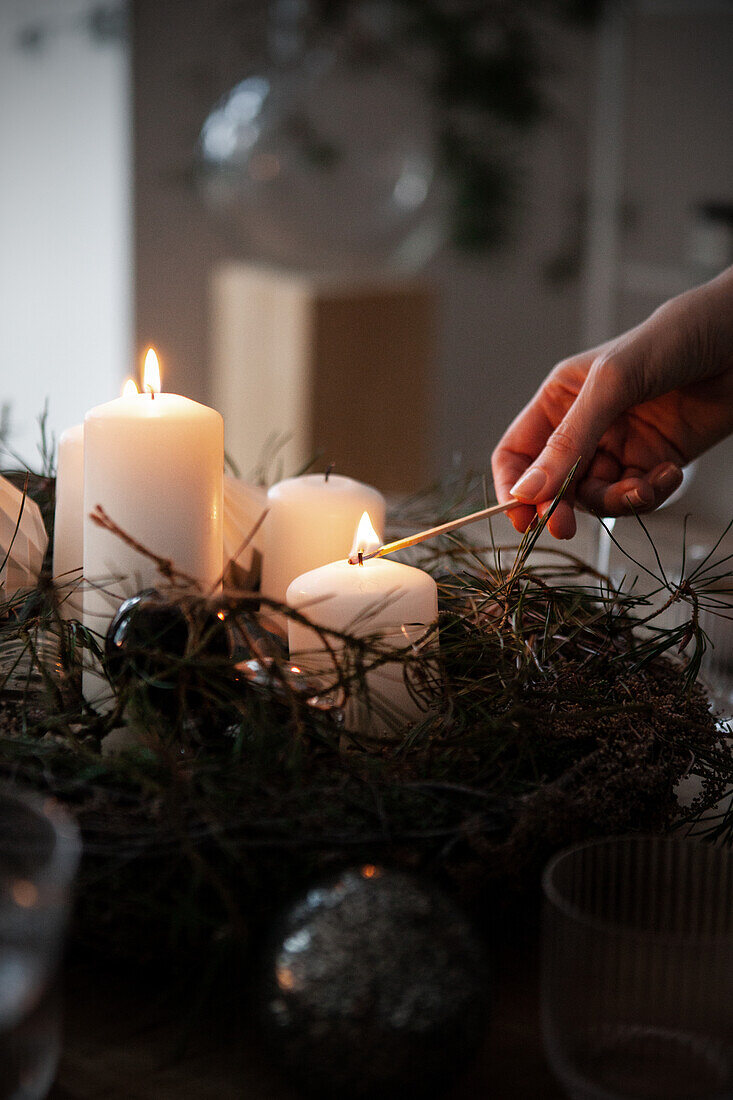 Hand entzündet Kerzen für weihnachtliche Tischdekoration