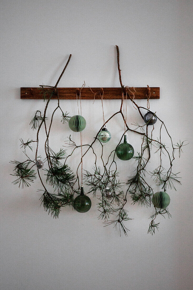 DIY wall decoration with green baubles and twigs