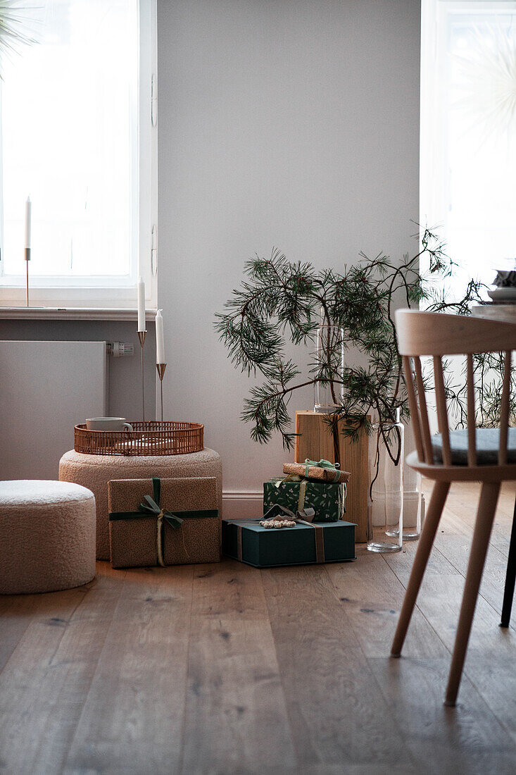 Living room corner with pine branches and presents on wooden floor