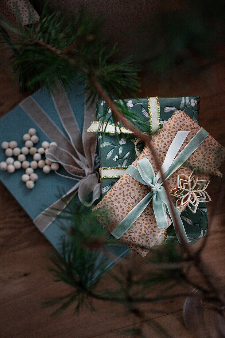 Wrapped Christmas presents and natural decorations on a wooden background