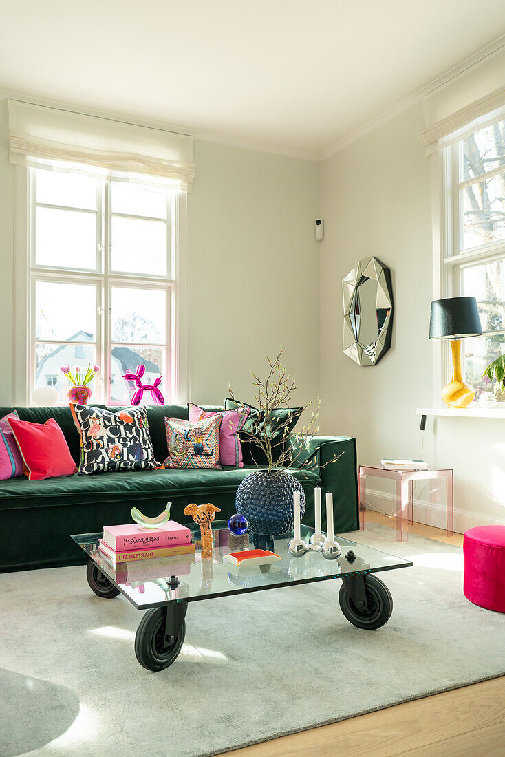 Colourful living room with green velvet sofa and glass coffee table