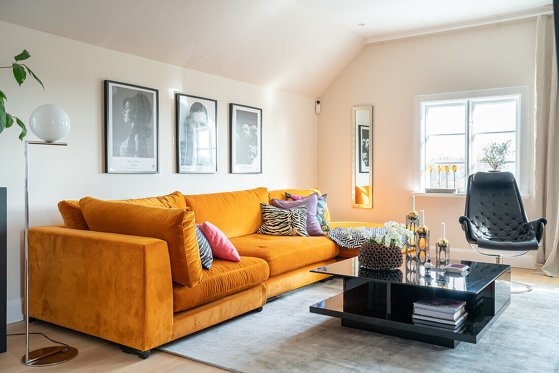 Mustard-colored sofa with cushions, black coffee table and black armchair in the living room