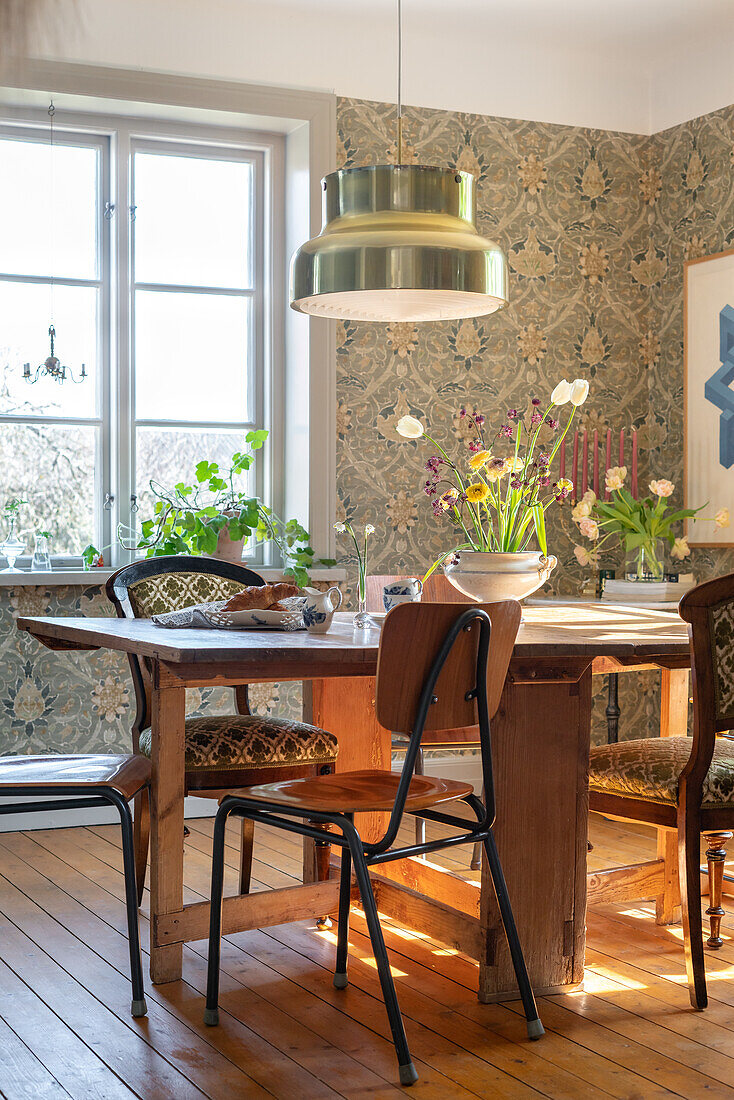 Dining area with floral wallpaper and vintage-style pendant light