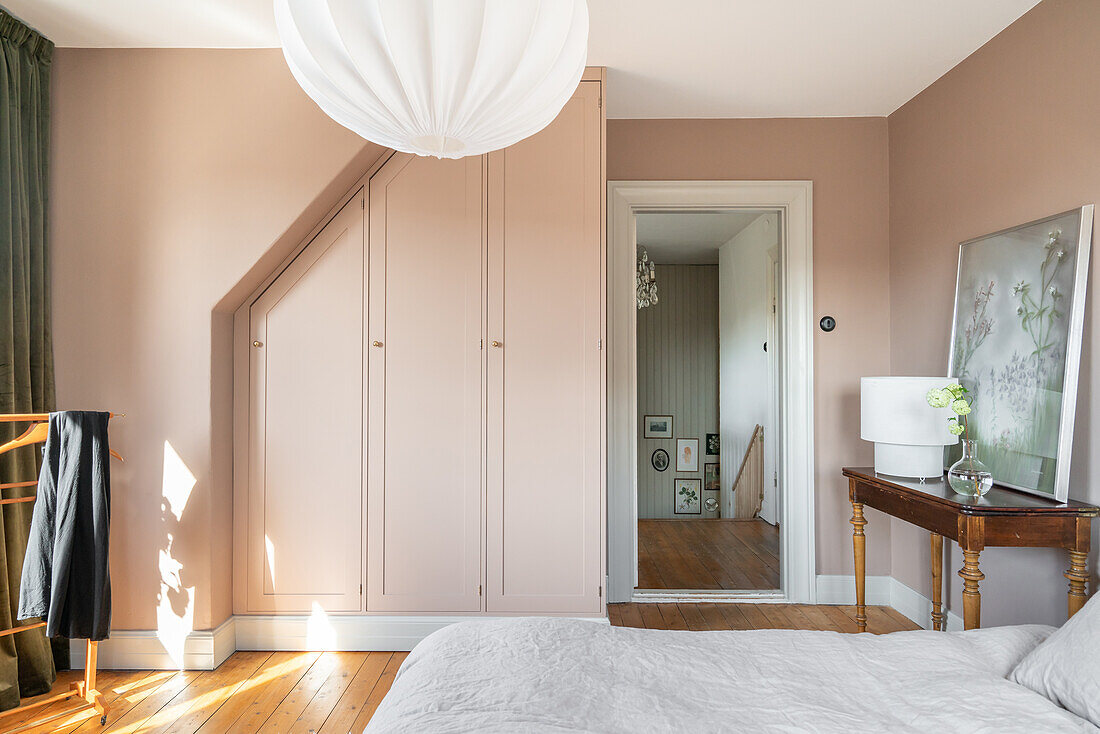 Schlafzimmer mit Einbauschrank und Wänden in Beige und Vintage-Möbeln